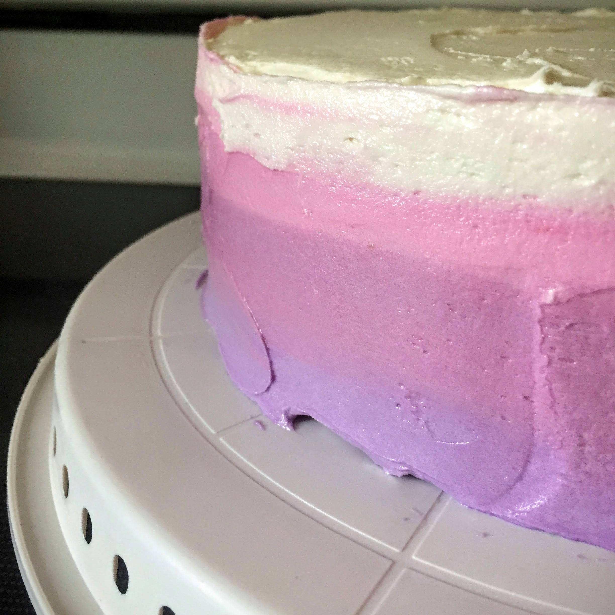 Here's the stress-inducing part: using an icing spatula (mine was a 13", and it was perfect for the job), slowly and evenly smooth the frosting along the sides of the cake, holding the spatula straight up and down. Slowly move your way around the cake, using the spatula to make the colors run together.